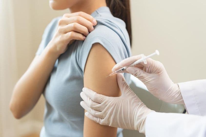 A doctor administering a vaccine to a patient at a clinic.
