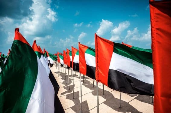 Flags of the United Arab Emirates waving in the wind at a popular Dubai beach.