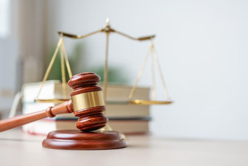 A wooden gavel on a wooden platform.