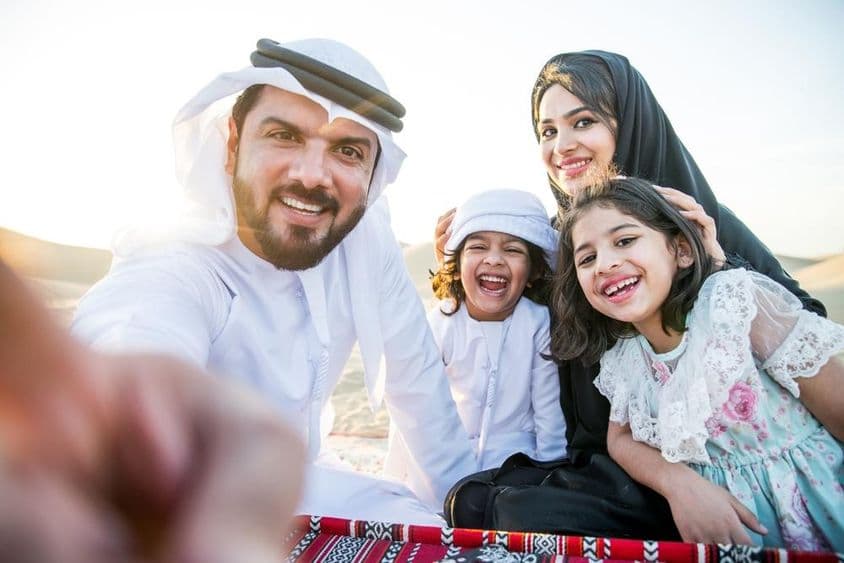 Happy family enjoying a wonderful day in the desert having a picnic.