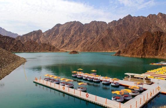 Beautiful deep green Hatta Lake surrounded by the Hajar mountains.