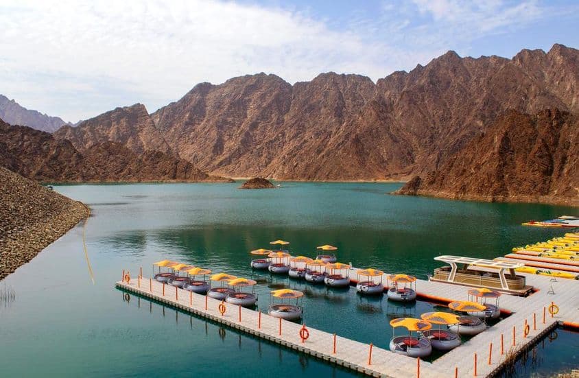 Beautiful deep green Hatta Lake surrounded by the Hajar mountains.