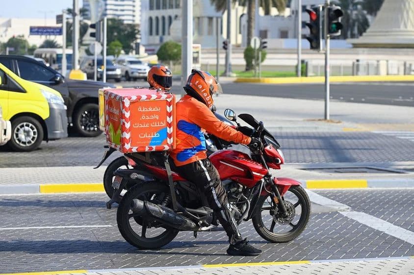 Talabat online food delivery company couriers on a street in Abu Dhabi.