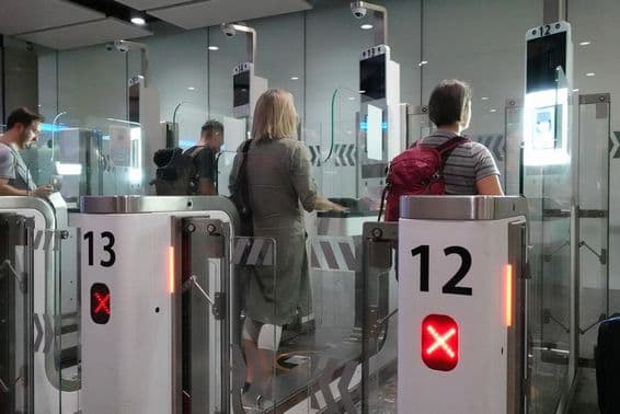 Air passengers passing through automated passport control checkpoints.