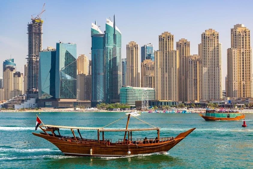 Old wooden dhow boat cruising in Dubai Marina.