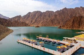 Beautiful deep green Hatta lake amidst Hajar mountains.