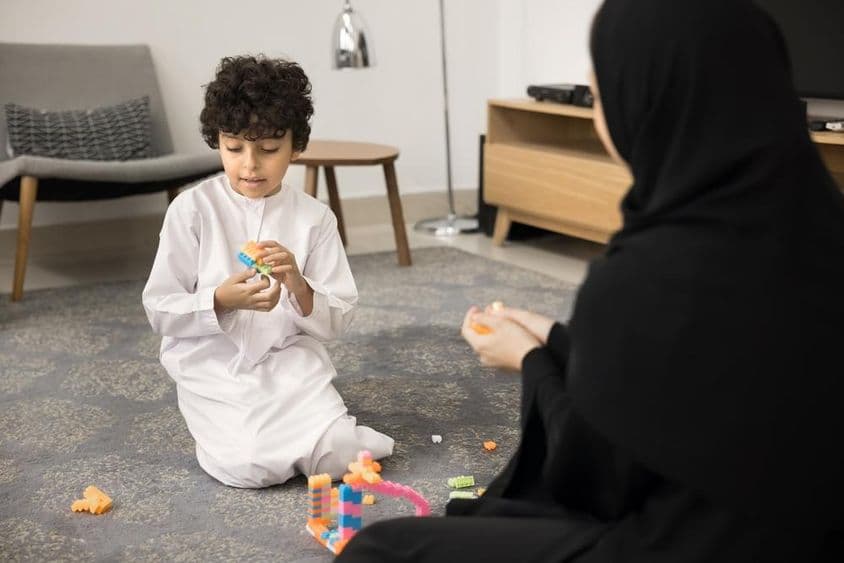 Young Arab woman teaching with creative toys at a Muslim home.