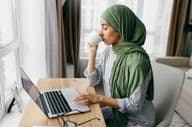 Arab businesswoman checking email notifications on a laptop.
