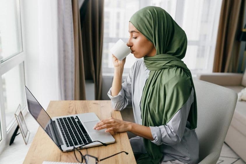 Arab businesswoman checking email notifications on a laptop.