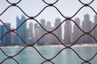 View of skyscrapers in Dubai through the iron bars.