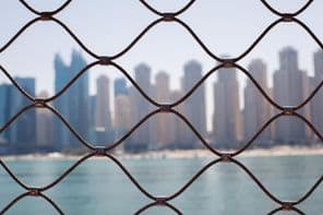 View of skyscrapers in Dubai through the iron bars.