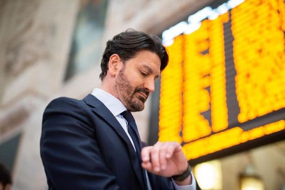 A commuter checks the time in front of a schedule.