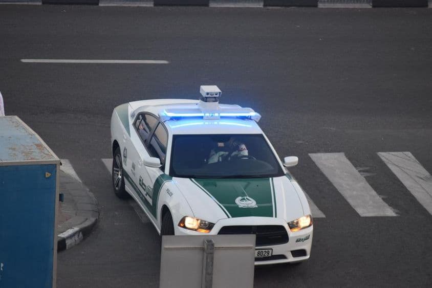A Dubai police car driving down the street.