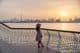 Young woman gazing at Dubai skyline under sunset.