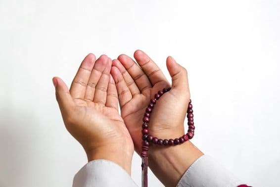 Muslim praying with prayer beads.