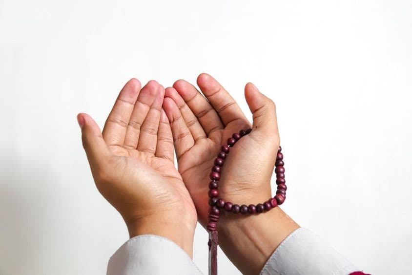 Muslim praying with prayer beads.