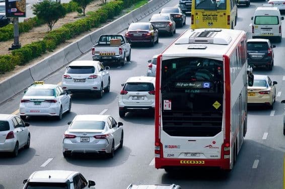 Double-decker bus route and daytime traffic on Dubai city streets.