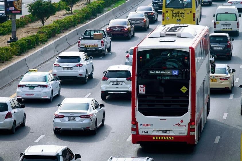 Double-decker bus route and daytime traffic on Dubai city streets.