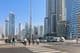 People walking at a pedestrian crossing in Dubai's business district.