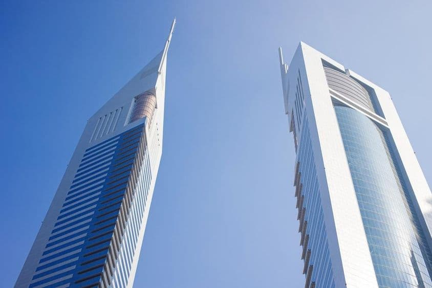 Two skyscrapers under a blue sky.
