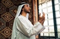 A young man praying in a mosque.