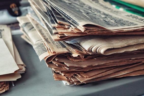 Old newspapers stacked with cobwebs.