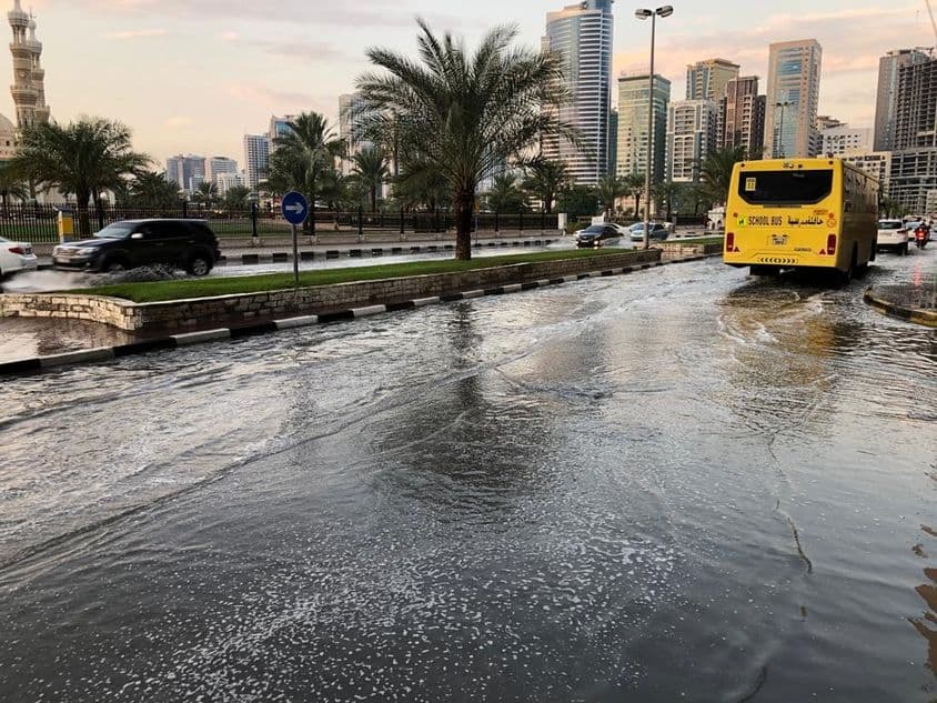 Traffic moving through a flooded urban road in Dubai.