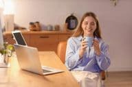 Young businesswoman drinking coffee in office at night.