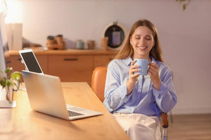 Young businesswoman drinking coffee in office at night.
