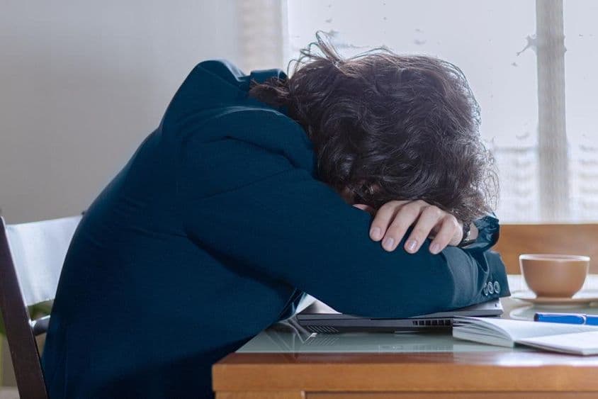 A person resting on their laptop at work on a Monday.