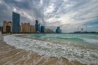 Bad weather in Dubai with rain, strong winds, and waves by the shore.