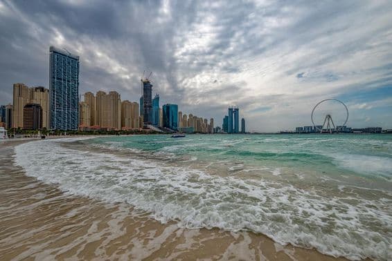 Bad weather in Dubai with rain, strong winds, and waves by the shore.