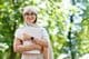 Back to school, Arab woman in hijab and glasses holding books in park.