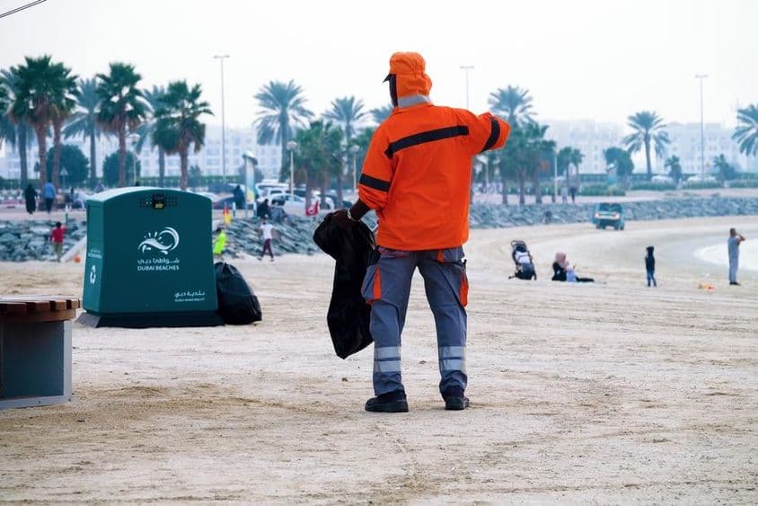 Dubai, United Arab Emirates, worker cleaning the beach.