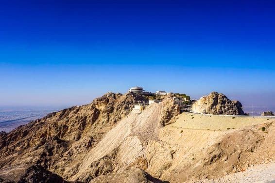 Al Ain Jebel Hafeet mountain landscape with peaks and buildings.