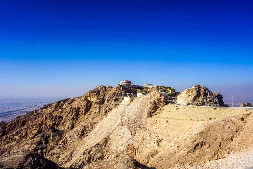 Al Ain Jebel Hafeet mountain landscape with peaks and buildings.