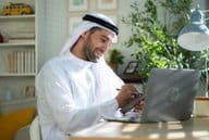 Young Arab businessman working from home on laptop.
