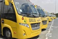 Several yellow school buses lined up in a parking lot in Dubai.