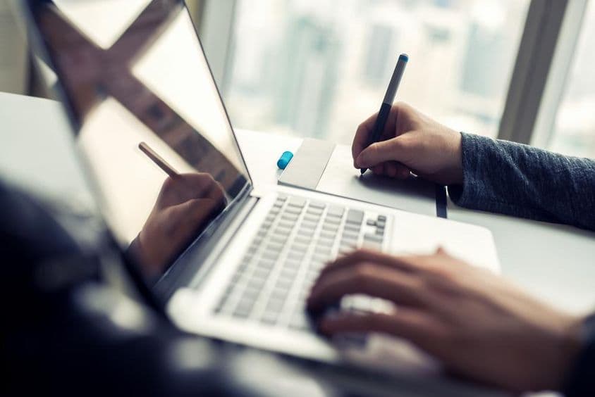 Close-up of a man working on a laptop.