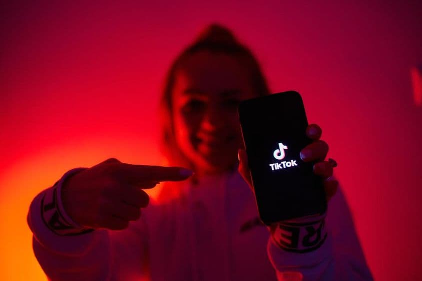 A girl with a dark side, holding a smartphone, promoting social media.