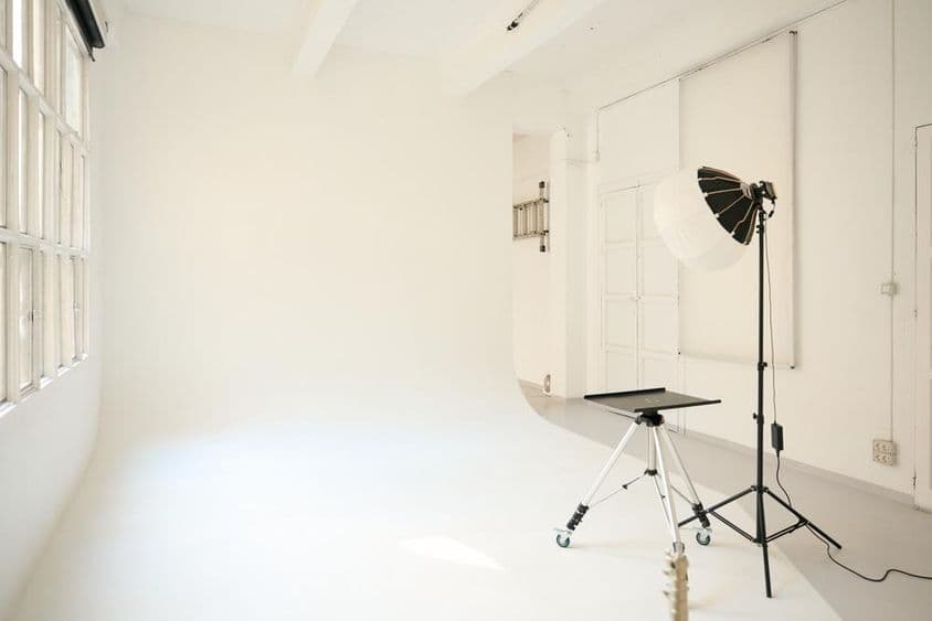 Empty photo studio equipped with lighting fixtures, ready for a shoot.