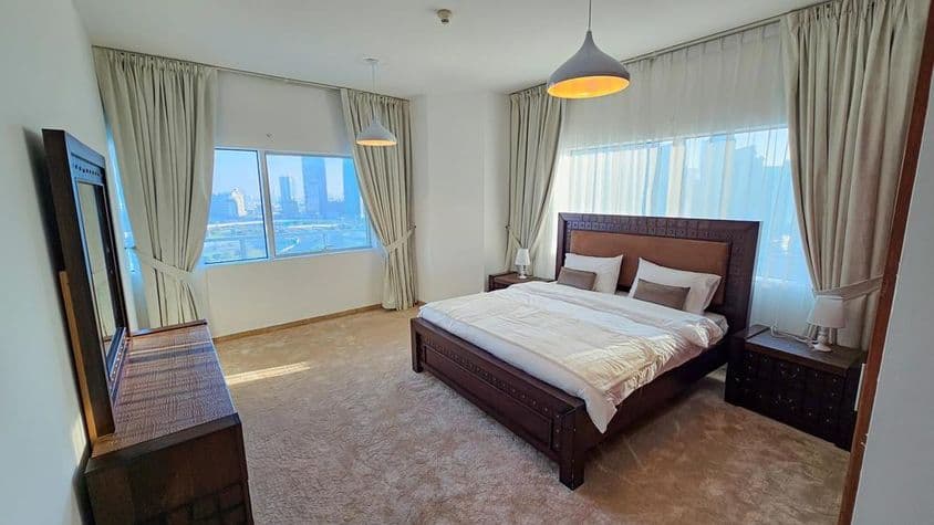 Bedroom in an apartment furnished with a king-size bed and windows.