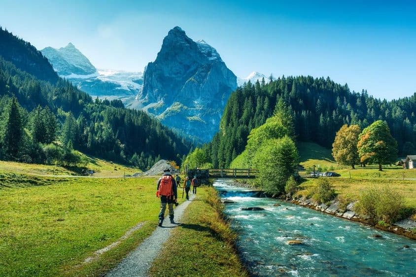 Group of tourists walking along a river in a forest in Bern canton, Switzerland.
