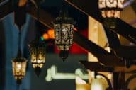 Arab street lanterns illuminate Dubai's night cityscape.