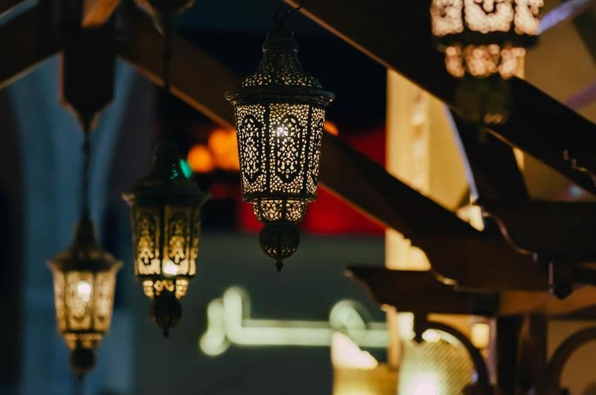 Arab street lanterns illuminate Dubai's night cityscape.