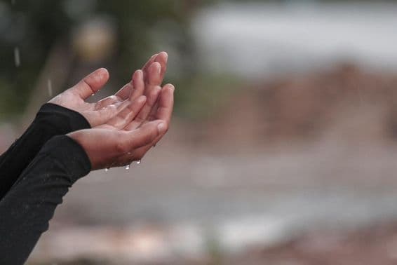 A woman's hand praying for rain.