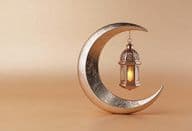 Decorative crescent with a glowing Ramadan lamp.