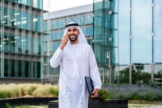 Arab Muslim businessman walking in Dubai business center.