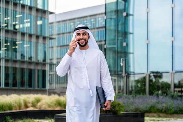 Arab Muslim businessman walking in Dubai business center.