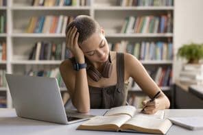 Left-handed teenage girl high school student prepares for university entrance.